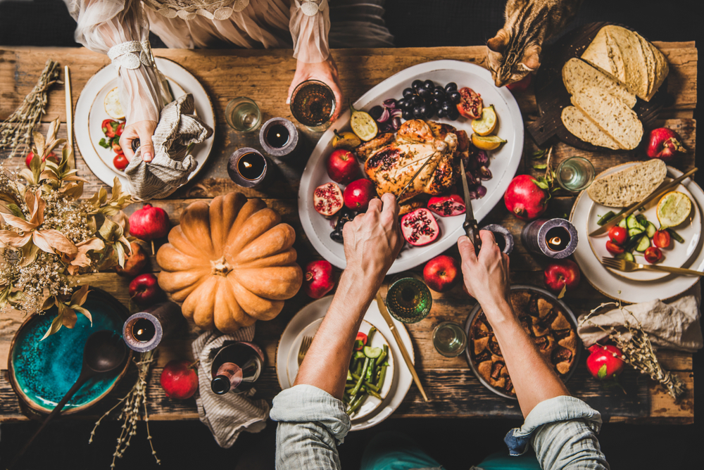 Thanksgiving table flat lay with roasted chicken and vegetables — holiday pet food safety reminder